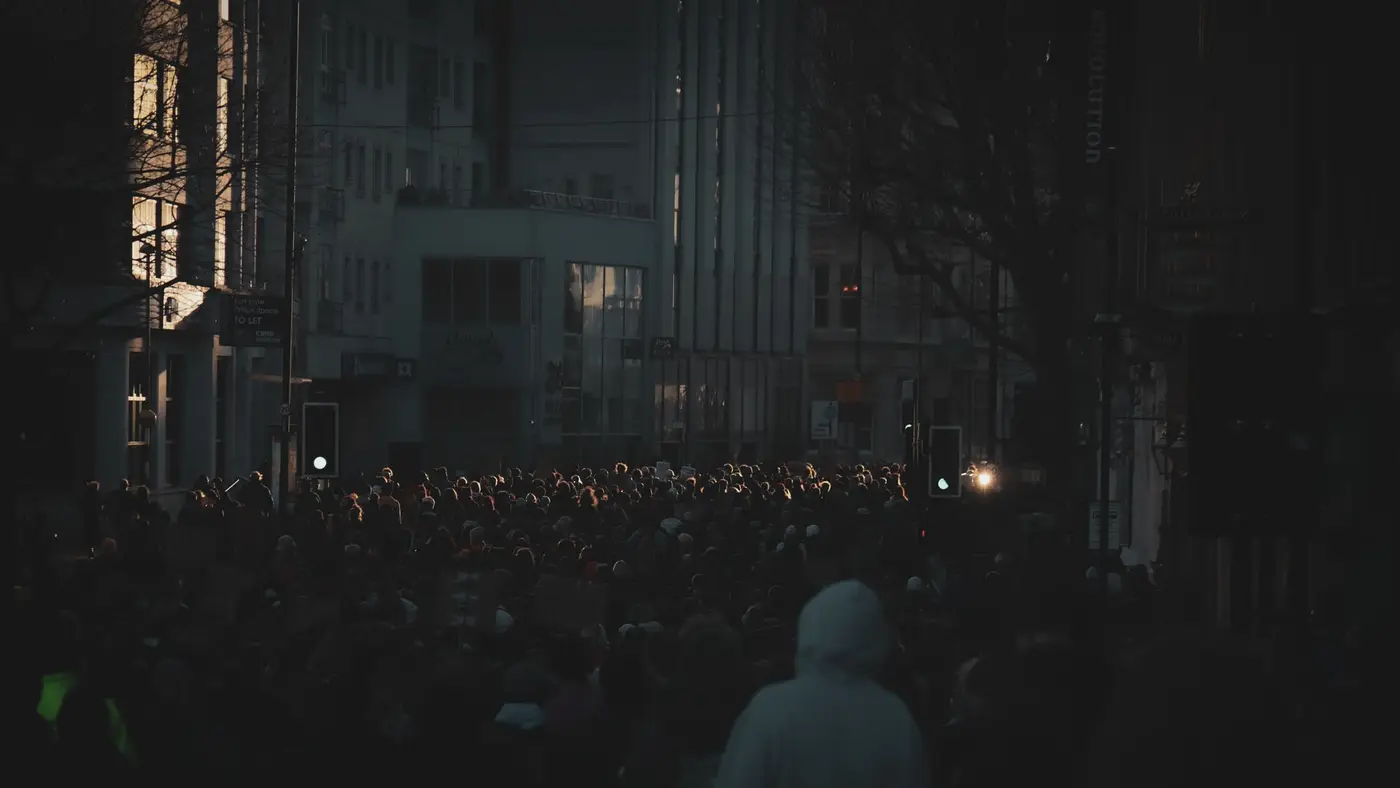 Silhouettes d'un rassemblement au crépuscule, évoquant une mobilisation de travailleurs.
