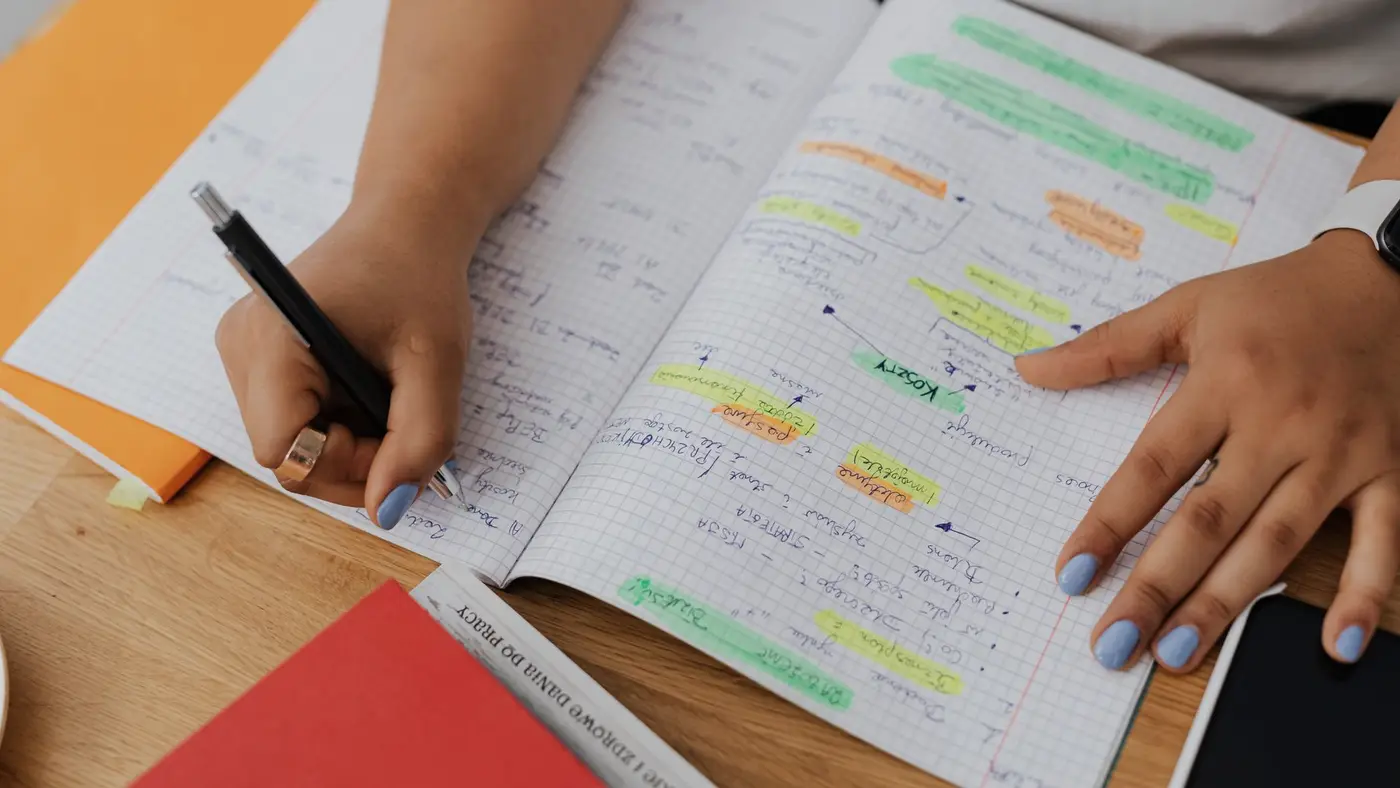Des notes manuscrites de révision sur un bureau : la copie d'un candidat, que l'outil doit d'abord lire avant de la corriger.