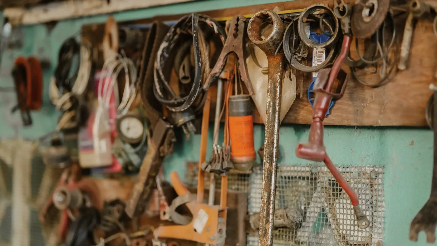 Des outils accrochés au mur d'un atelier : chez un carrossier, les devis et contrats clients valent autant pour un fraudeur que l'outillage.
