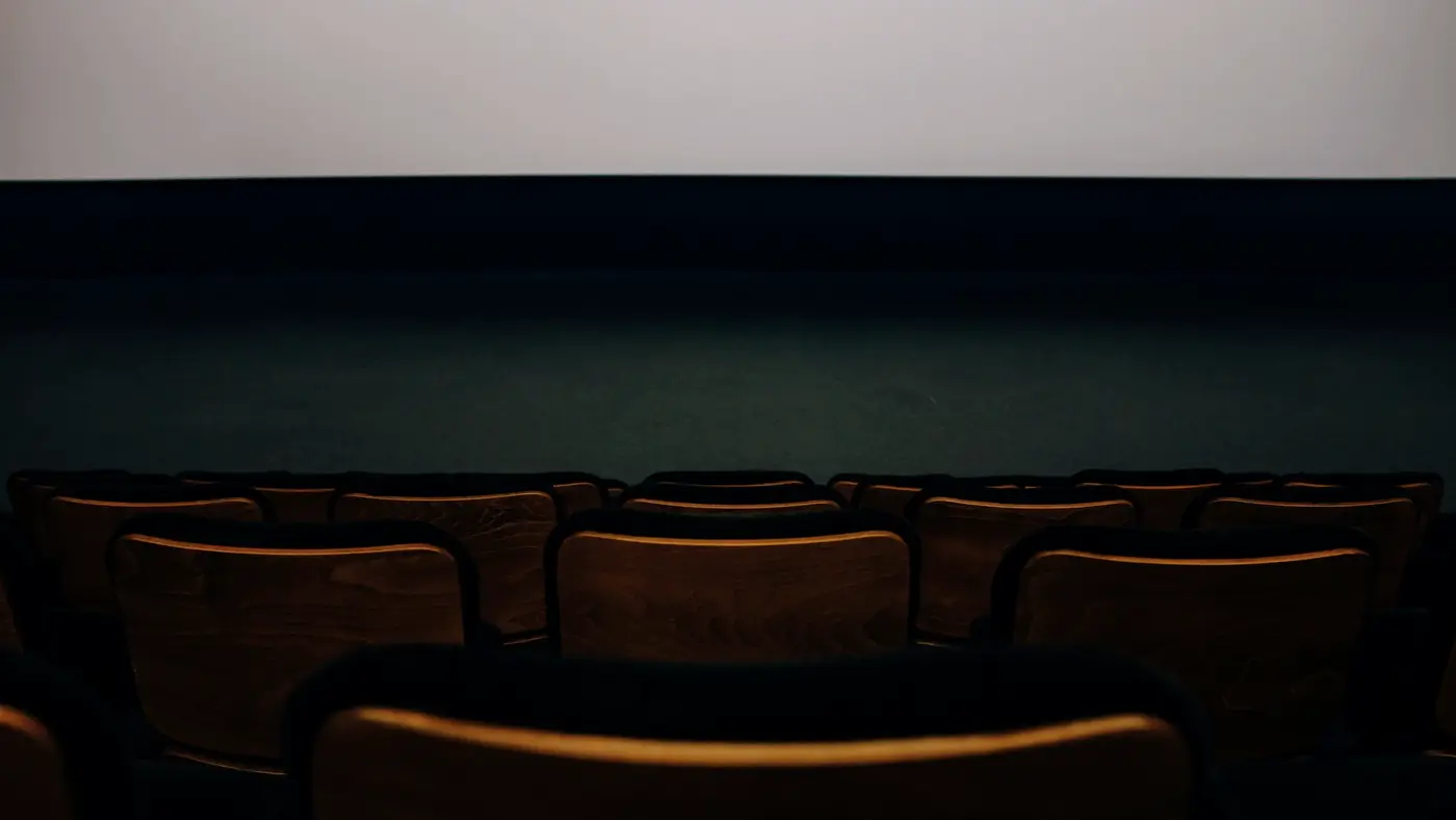 Une salle de théâtre vide dans la pénombre : l'école d'acteurs visée par la revendication n'a rien confirmé publiquement.