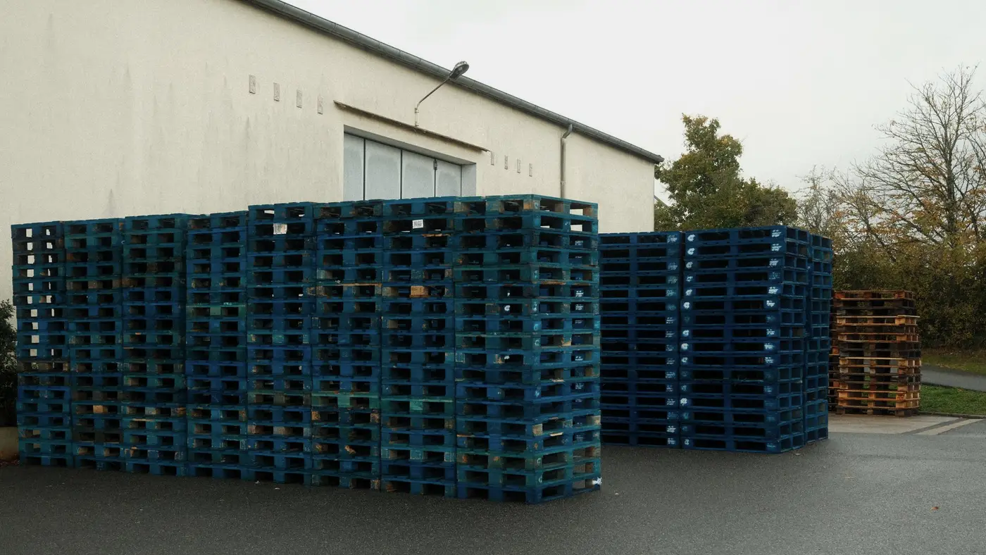 Des piles de palettes devant un entrepôt : dans une double extorsion, les salariés sont les premières victimes oubliées.