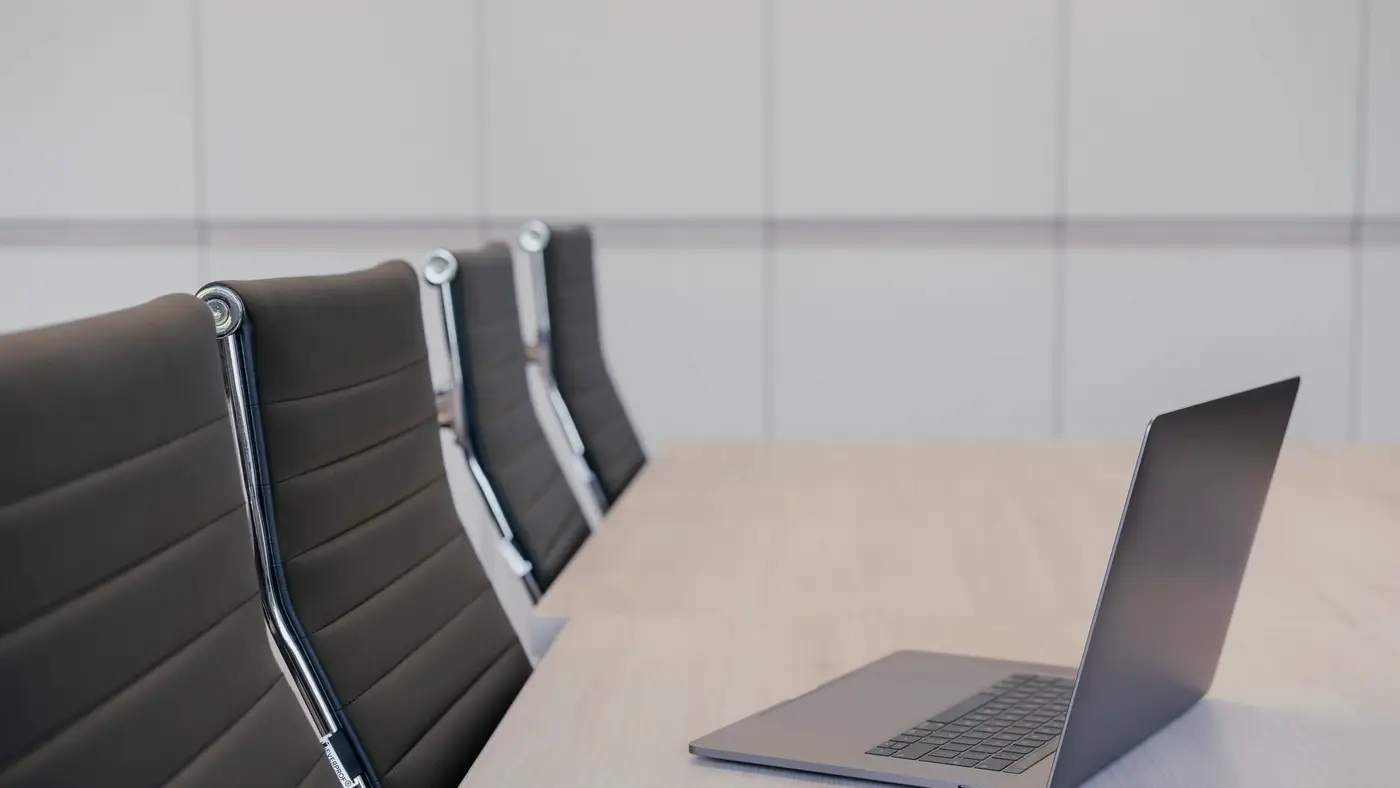 Une table de réunion, des fauteuils vides et un ordinateur ouvert : dans une petite entreprise, la charte d’usage de l’IA n’attend aucune loi.