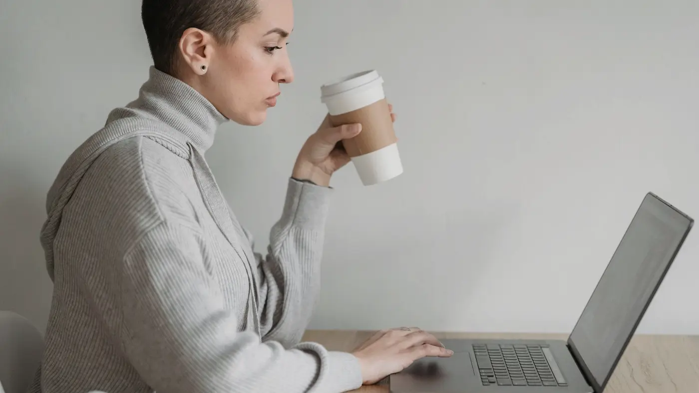 Une salariée travaille seule sur son ordinateur portable, sans collègue ni responsable autour d'elle.