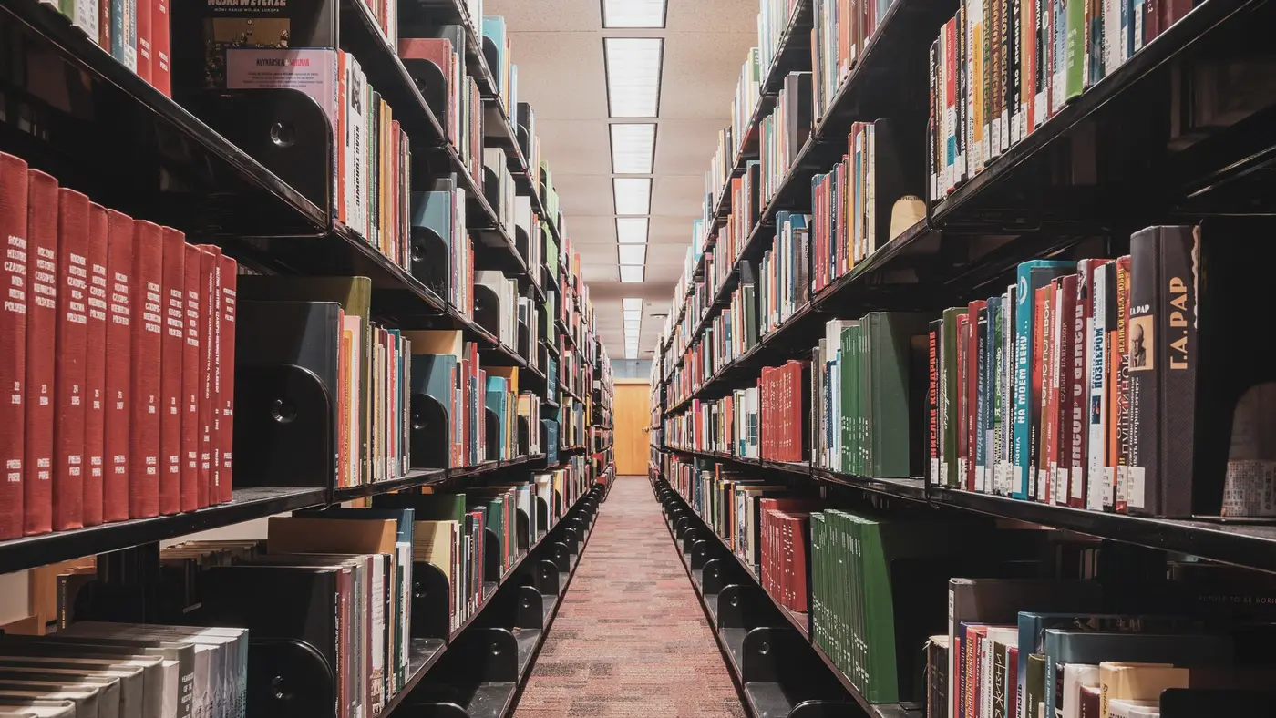 Une allée de rayonnages de bibliothèque : la boutique en ligne d’un éditeur universitaire encaisse des paiements comme n’importe quel commerce.